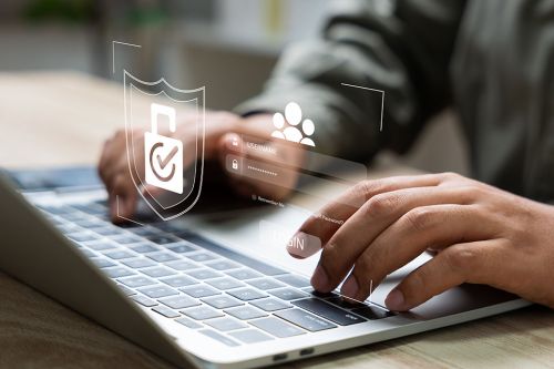 Mann tippt auf Laptop